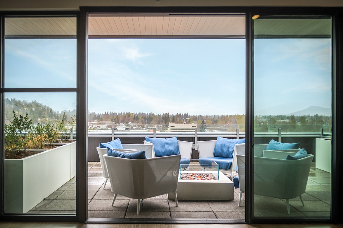 Rooftop lounge a firepit and comfortable seating overlooking the city of Eugene
