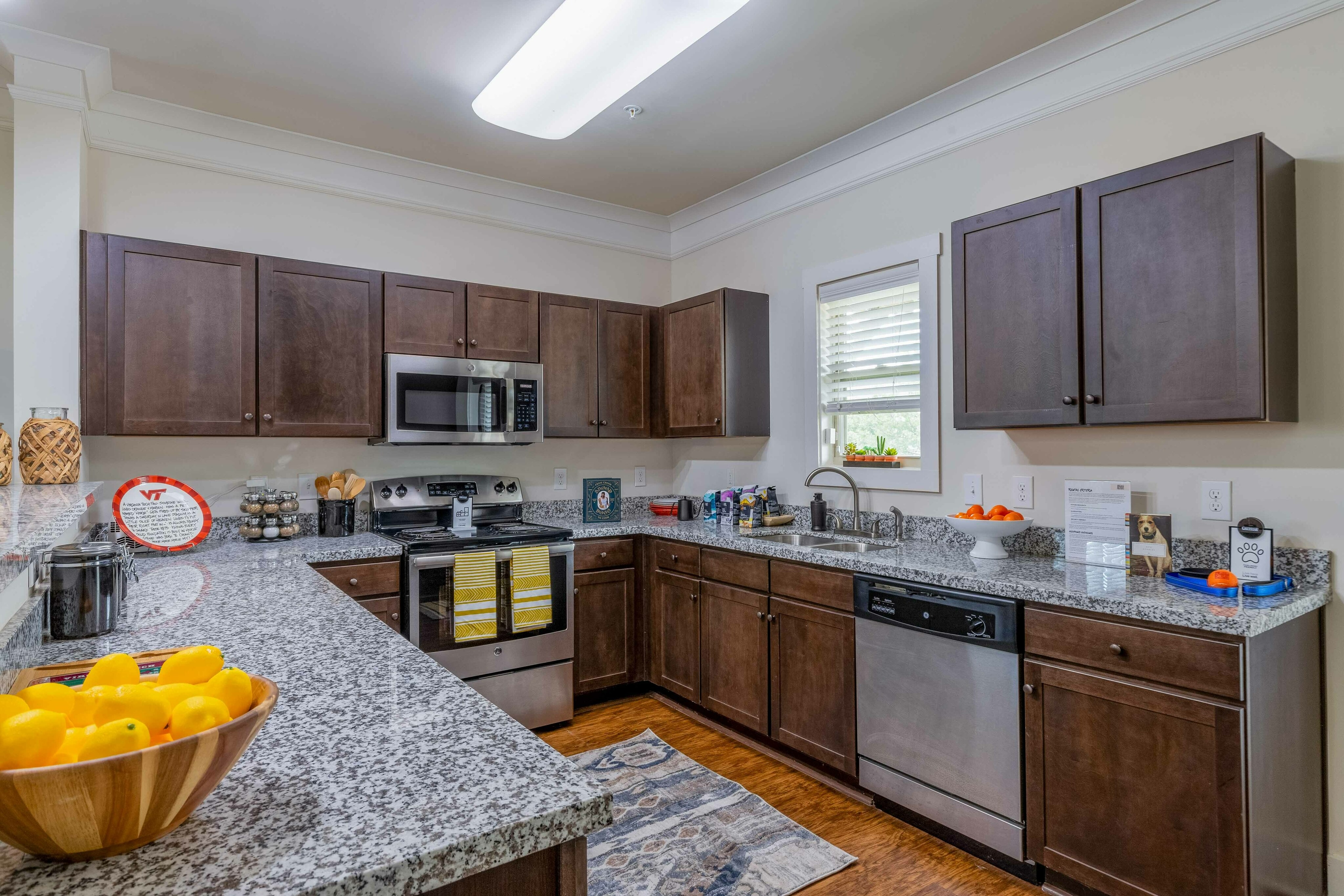 Model apartment kitchen with brown cabinets and stainless steel appliances
