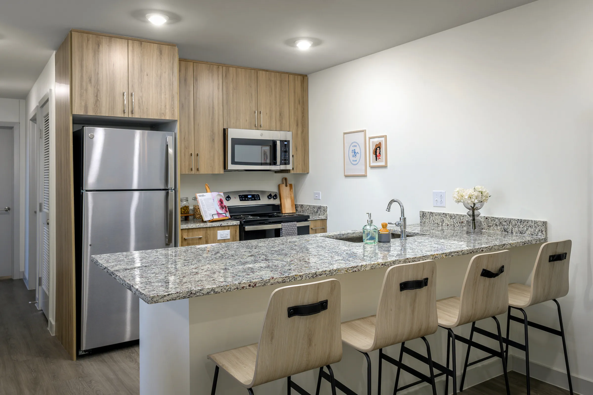 Model apartment kitchen with granite countertops and stainless steel appliances