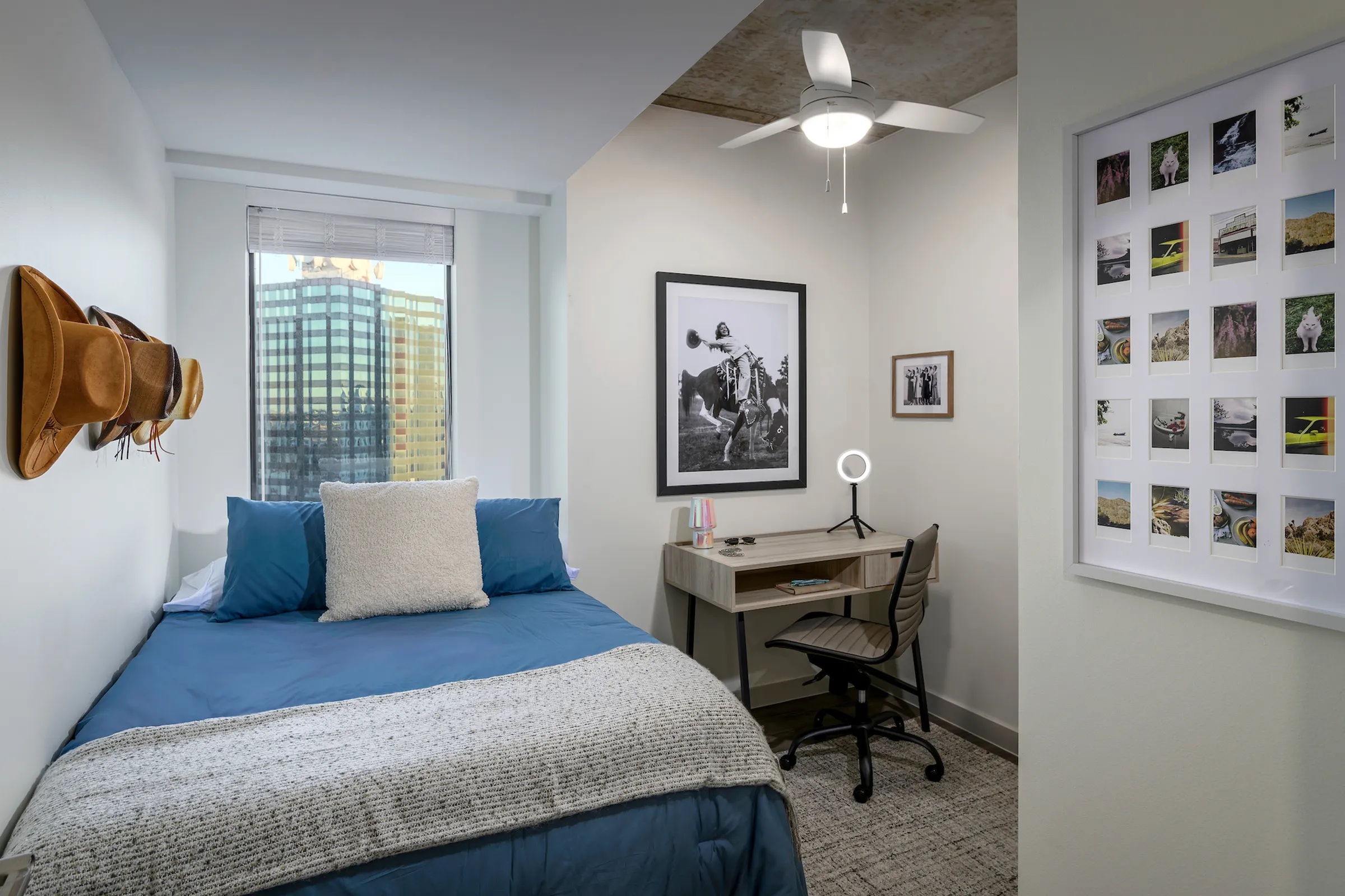 Model apartment bedroom with full size bed, desk, and desk chair