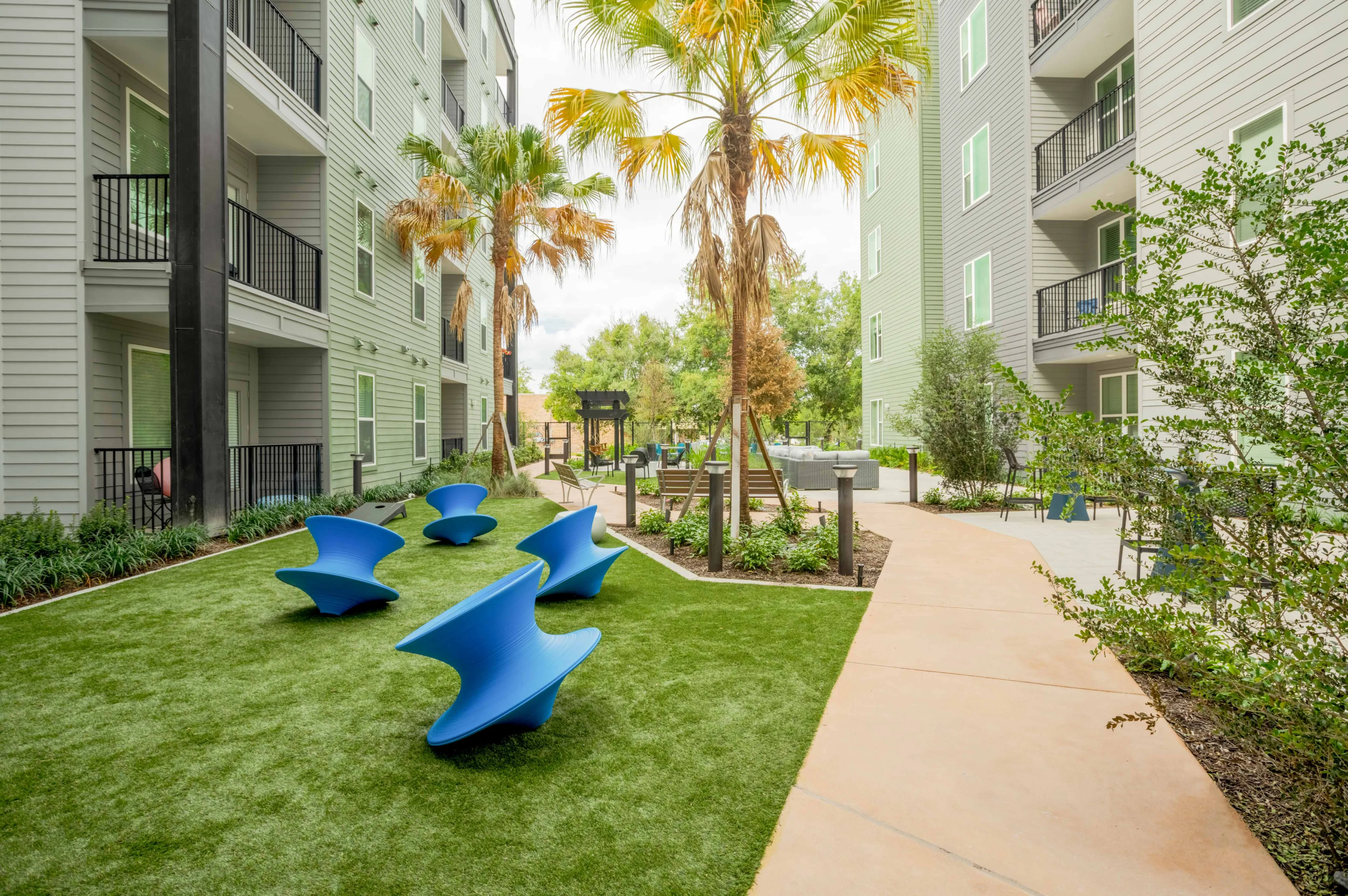 Outdoor lounge space with blue chairs on the lush green grass