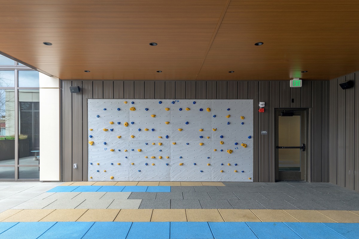 Outdoor rock climbing wall with colorful floor mats