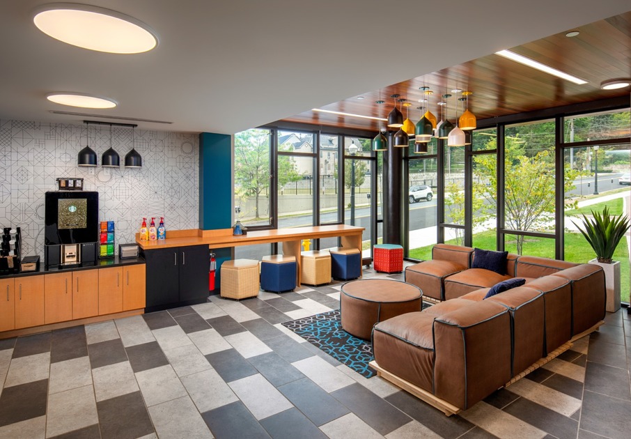 Resident lounge Southside Commons apartments for rent in Bethlehem, PA, featuring leather couches and a coffee station.