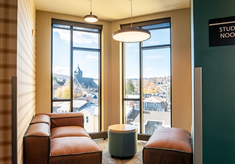 Resident lounge at Southside Commons apartments for rent in Bethlehem, PA, featuring floor to ceiling windows.