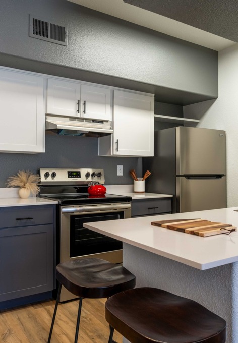 Model kitchen with navy and white cabinets and stainless steel appliances