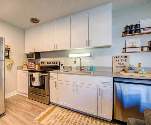 Model apartment kitchen with stainless steel appliances and white cabinets