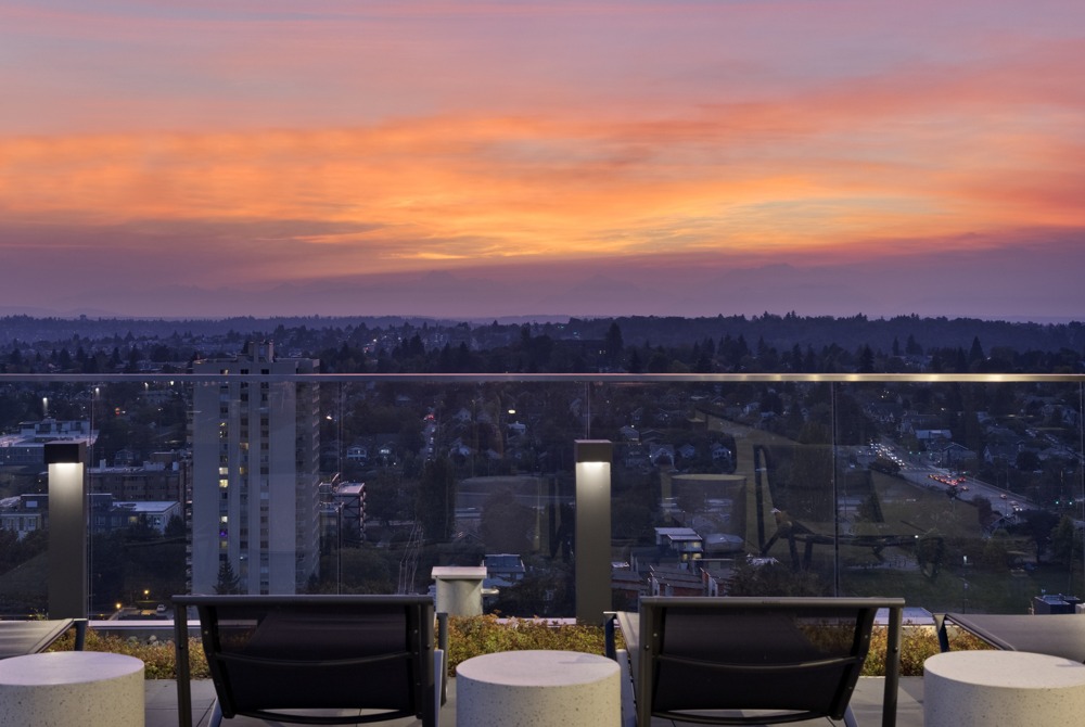Rooftop lounge overlooking the sun setting over downtown Seattle