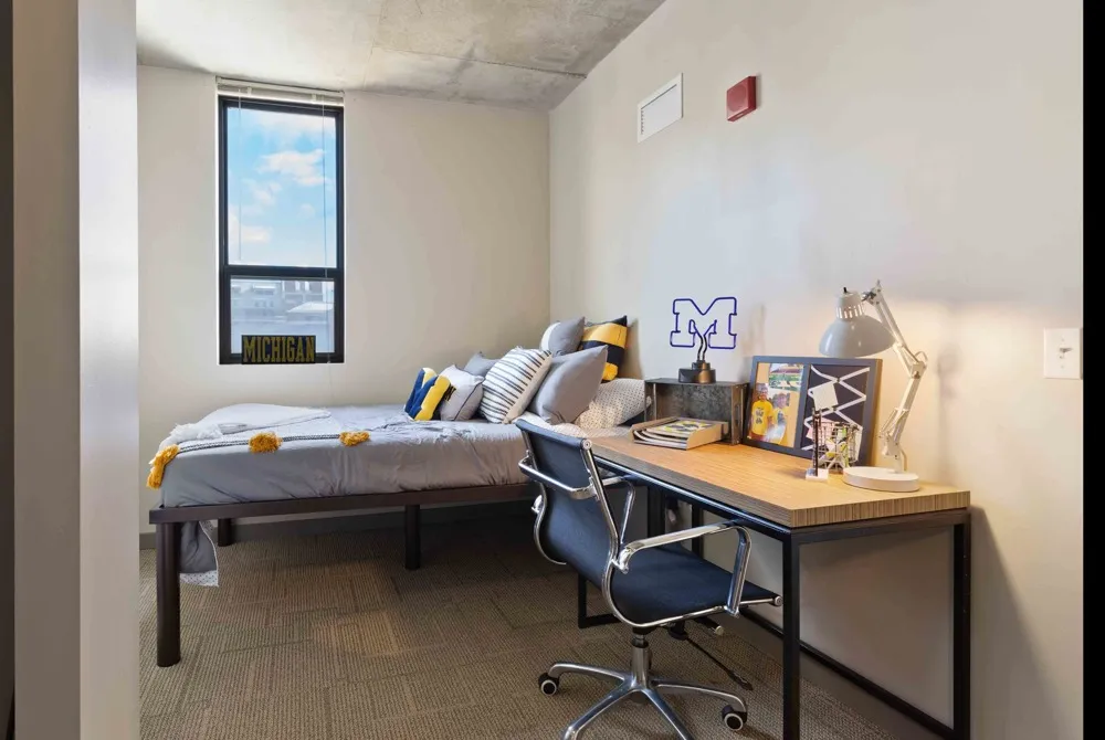 Model apartment bedroom showcasing the bed, desk, and chair