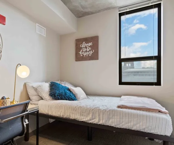 Model apartment bedroom showcasing the bed, desk, and chair