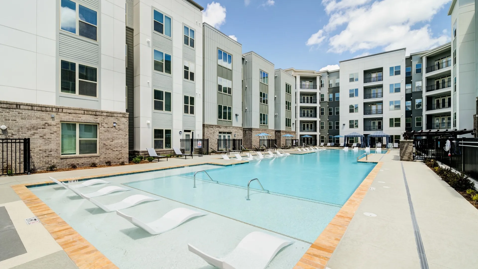 Outdoor swimming pool at Union Chapel Hill apartments in Chapel Hill, NC, featuring lounge chairs and balconies.