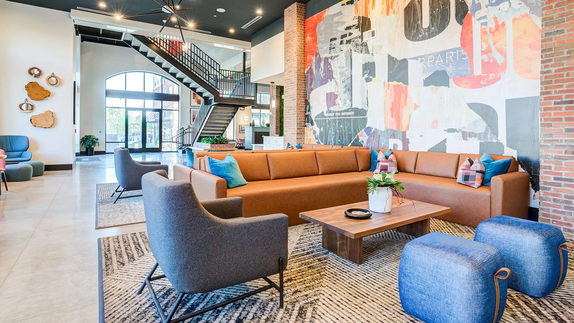Resident lounge at Union on Frank apartments in Tuscaloosa, AL, featuring cushioned chairs and couches.