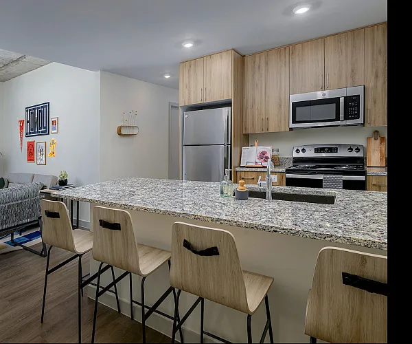 Model apartment kitchen with granite countertops and stainless steel appliances