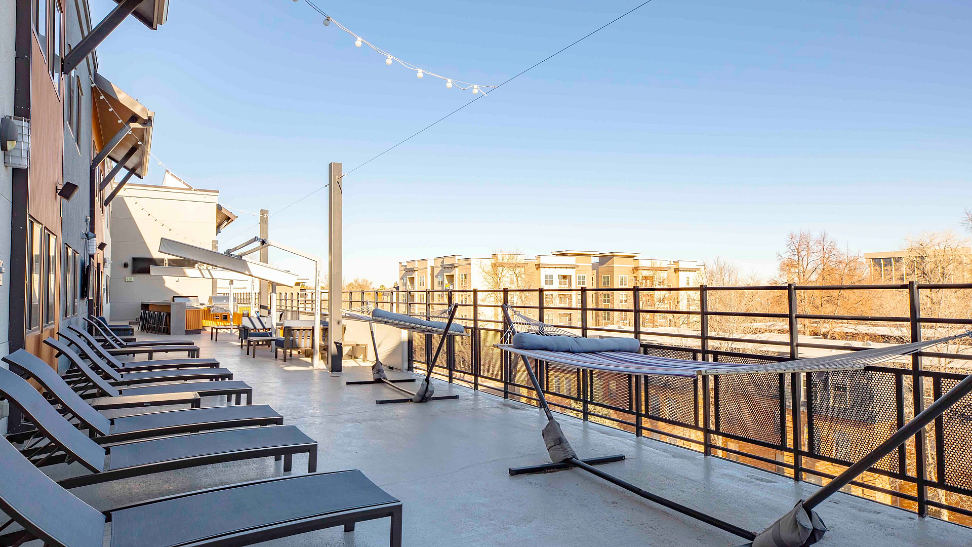 Rooftop lounge with hammocks and sun loungers overlooking the city of Fort Collins
