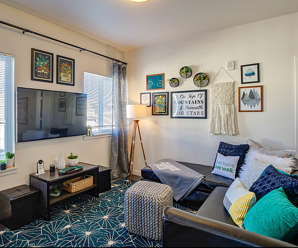 Model apartment with a couch facing a flat screen tv