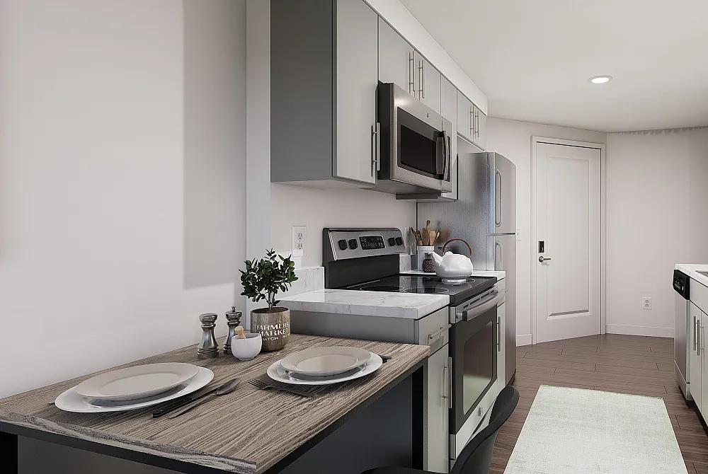 Model kitchen with stainless steel appliances and dining table at The Accolade on Chestnut apartments in University City, PA.