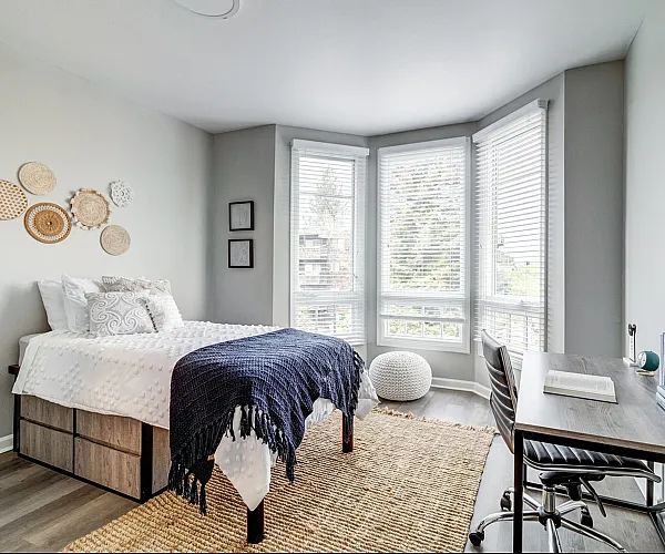 Model apartment living room with hardwood style flooring and a baywindow