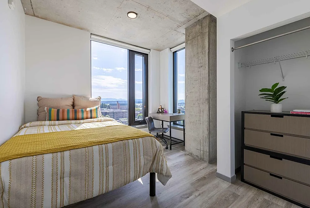 Model apartment bedroom showcasing the full size bed, desk, and chairs