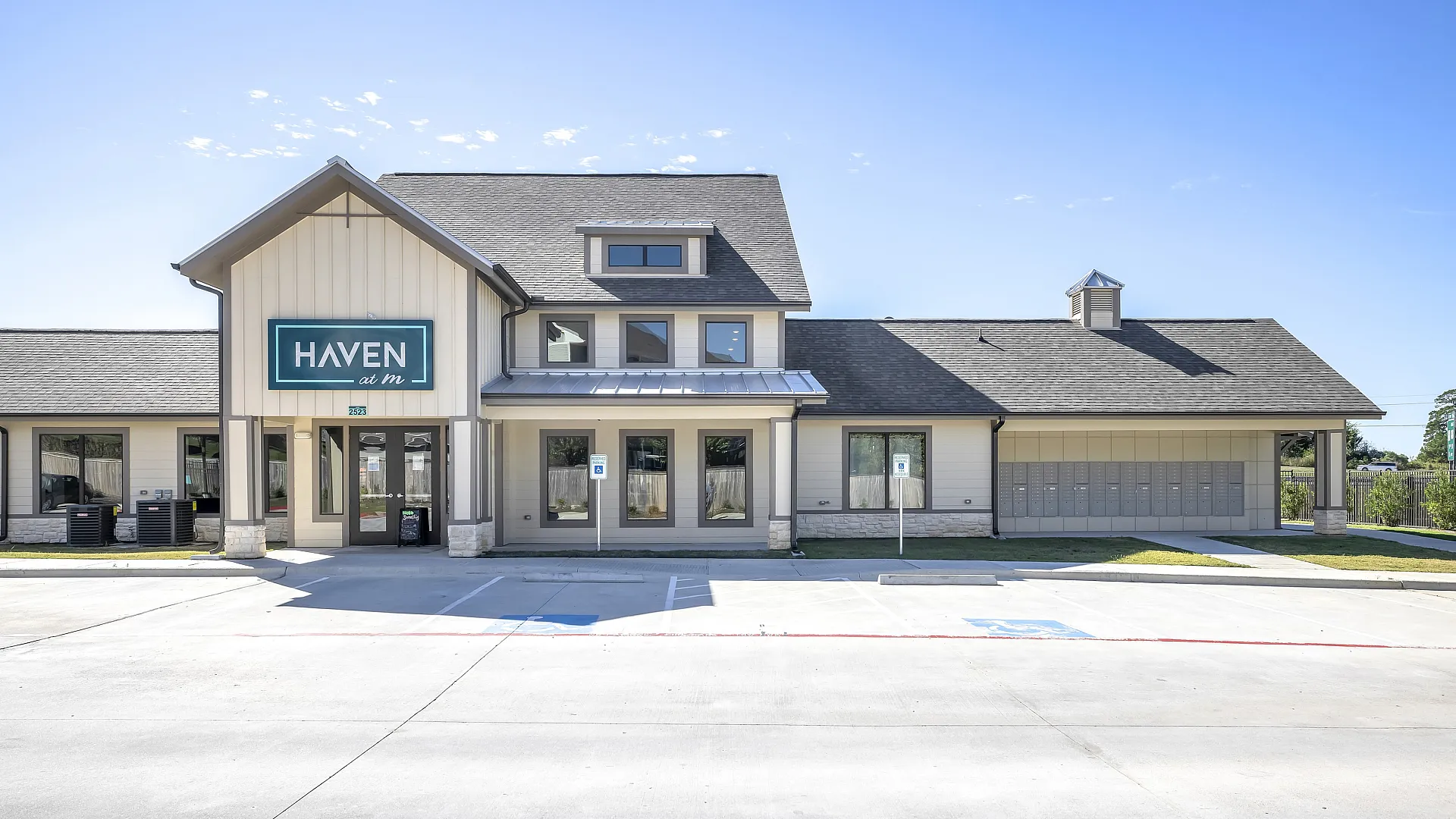 Inviting modern apartment complex exterior with elegant design and ample parking, featuring a charming entrance marked by Haven signage.