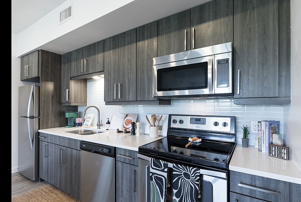 Modern kitchen with sleek stainless steel appliances, elegant dark wood cabinetry, and a bright, inviting atmosphere.