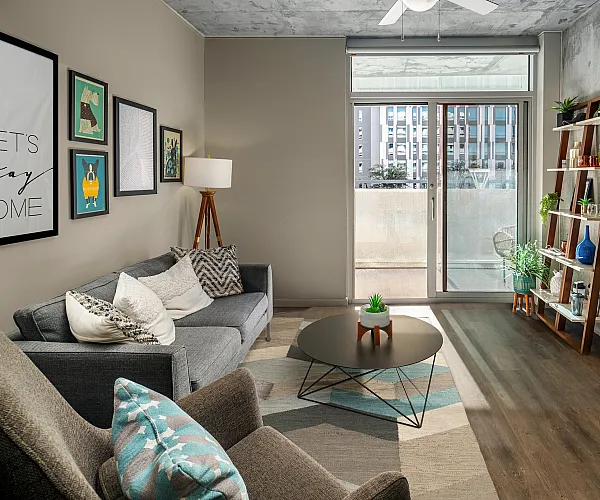 Modern urban living room with stylish decor, floor-to-ceiling windows, and a cozy seating arrangement.
