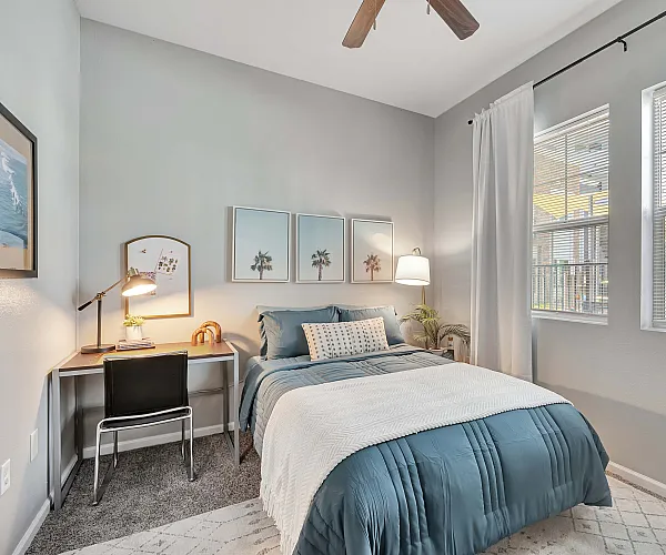 Cozy bedroom with modern decor, featuring a comfortable bed, stylish desk, and bright windows, perfect for creating a relaxing atmosphere.