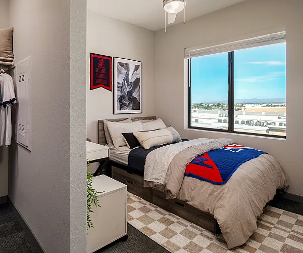 Cozy bedroom featuring modern decor, a comfortable bed with plush pillows, and a large window offering stunning views.