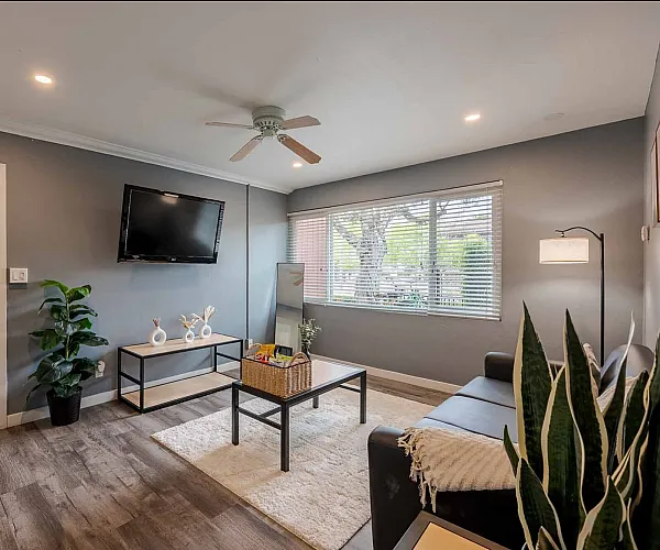 Inviting living room featuring modern decor, sleek wooden floors, and abundant natural light, designed for comfort and style.