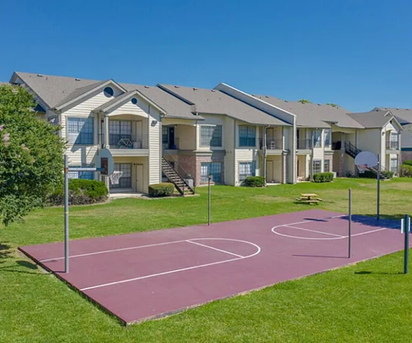Spacious apartment complex featuring well-maintained lawns and a vibrant basketball court, perfect for active lifestyles.