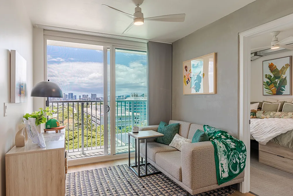 Chic apartment interior featuring a cozy living room with a modern beige sofa, vibrant artwork, and a spacious balcony overlooking the cityscape.