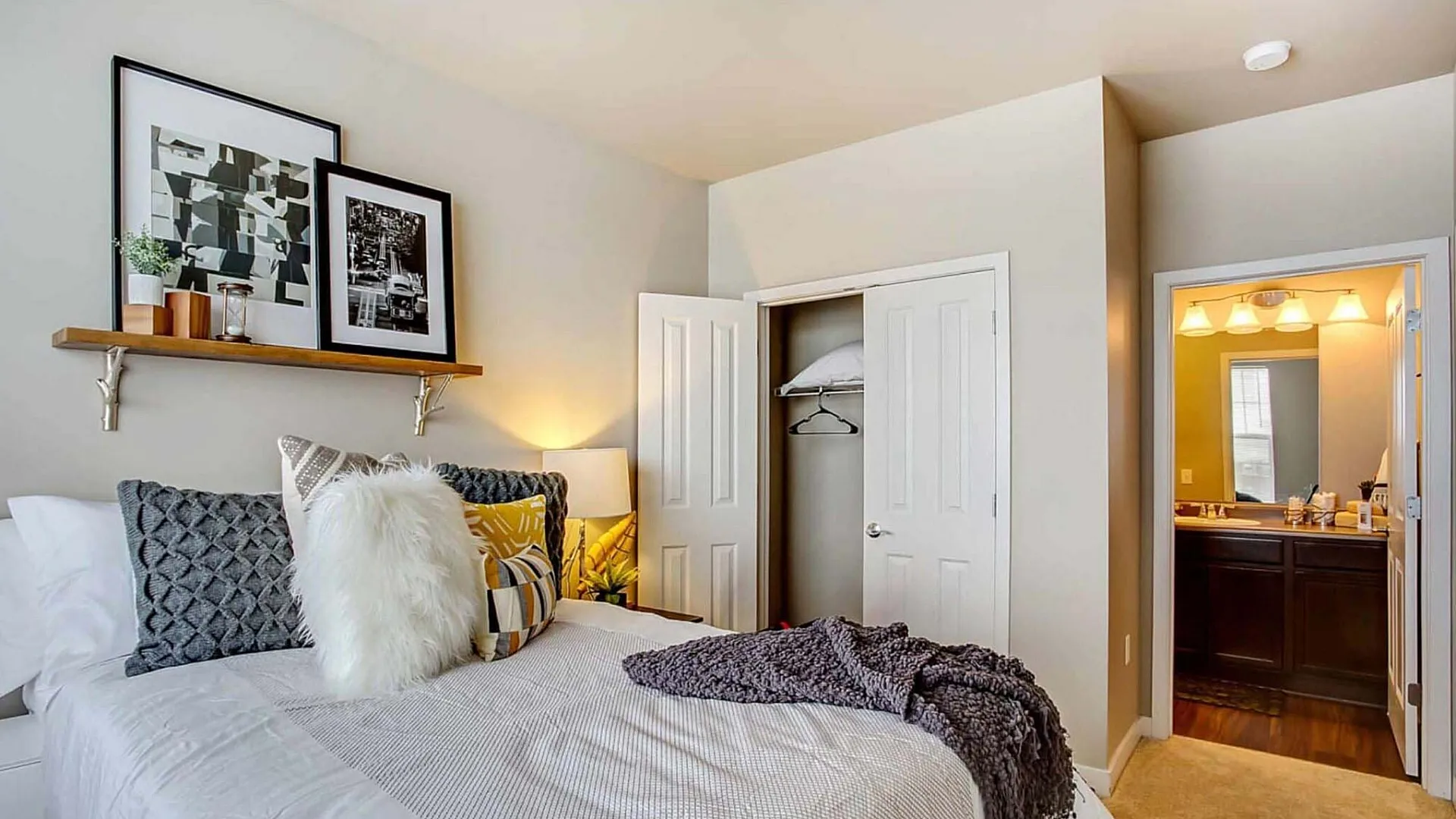 Inviting bedroom with cozy decor, elegant artwork, ample natural light, and a connected modern bathroom.