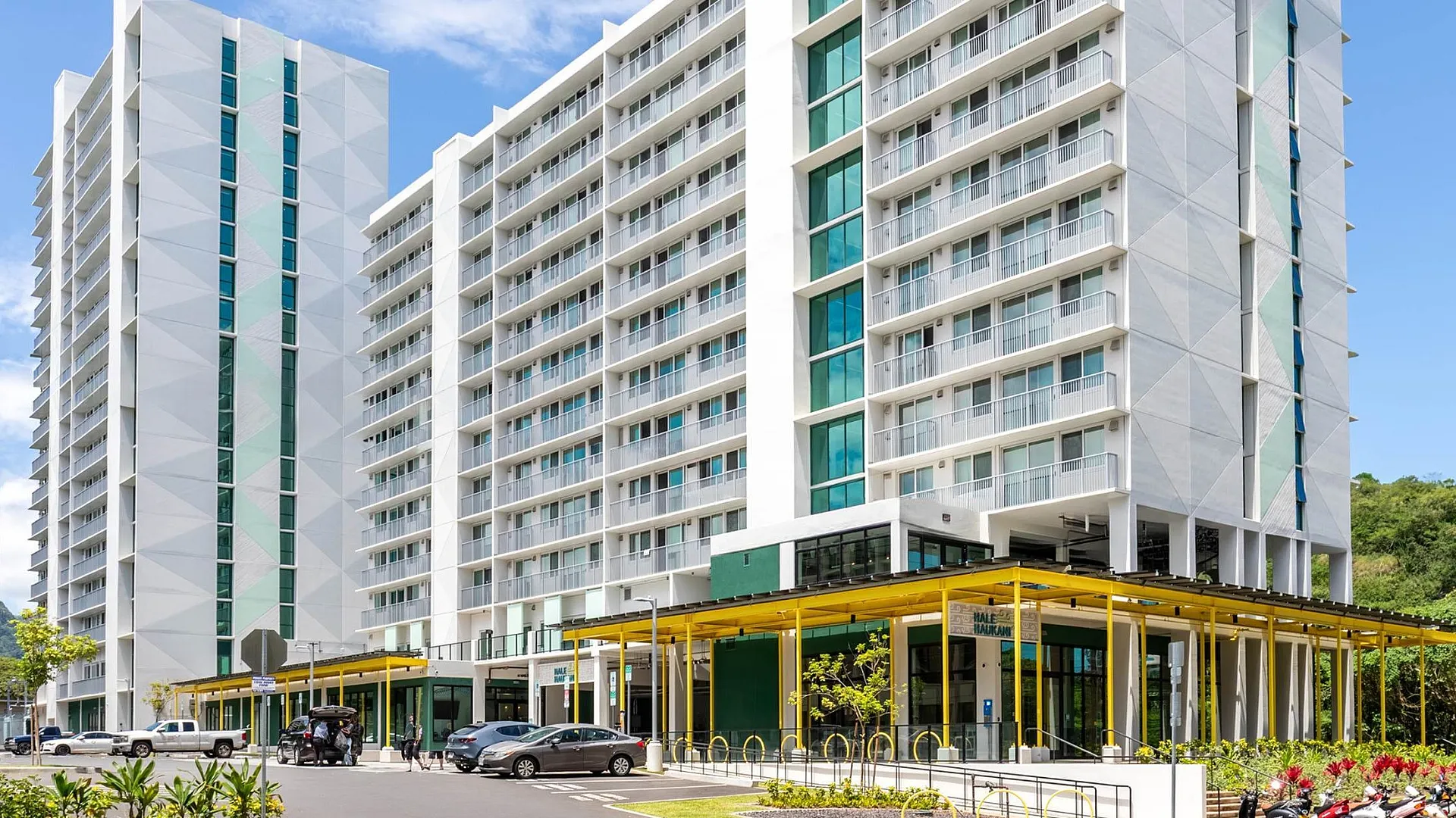Modern high-rise apartment building with elegant facade, lush landscaping, and convenient urban location.