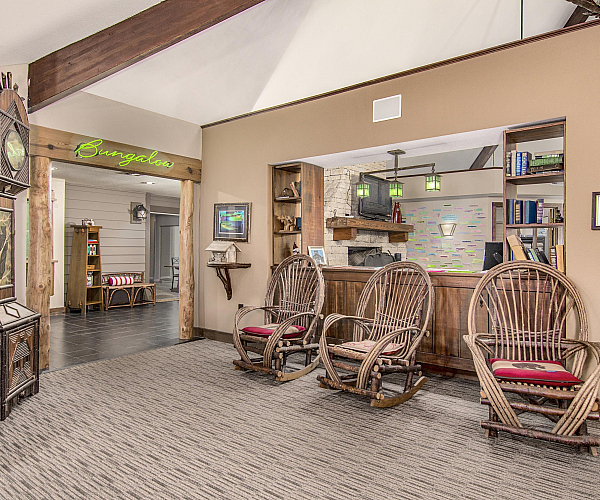 Charming interior lounge area with rustic rocking chairs, wooden beams, and cozy lighting, showcasing a warm and inviting ambiance.