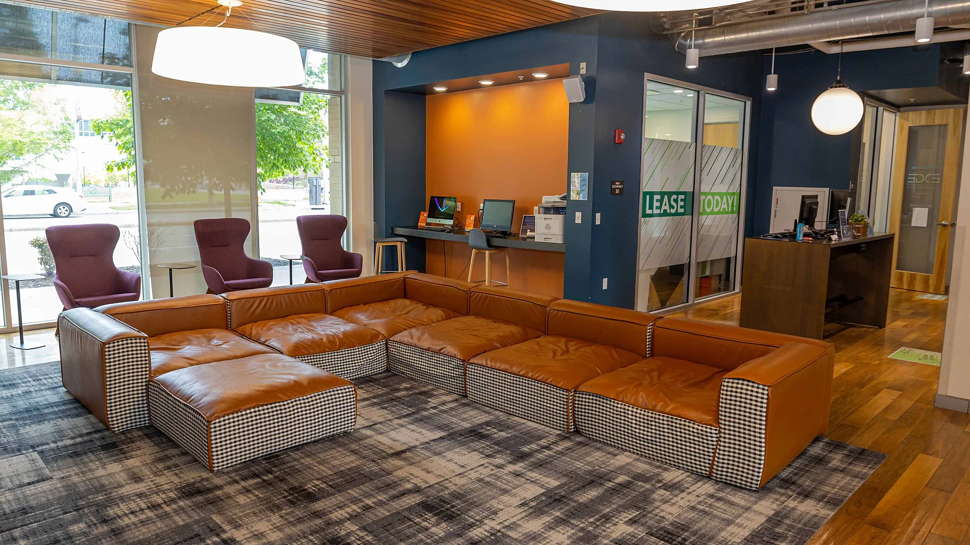 Modern apartment lobby with stylish seating, natural light, and inviting workspace, showcasing urban comfort and convenience.