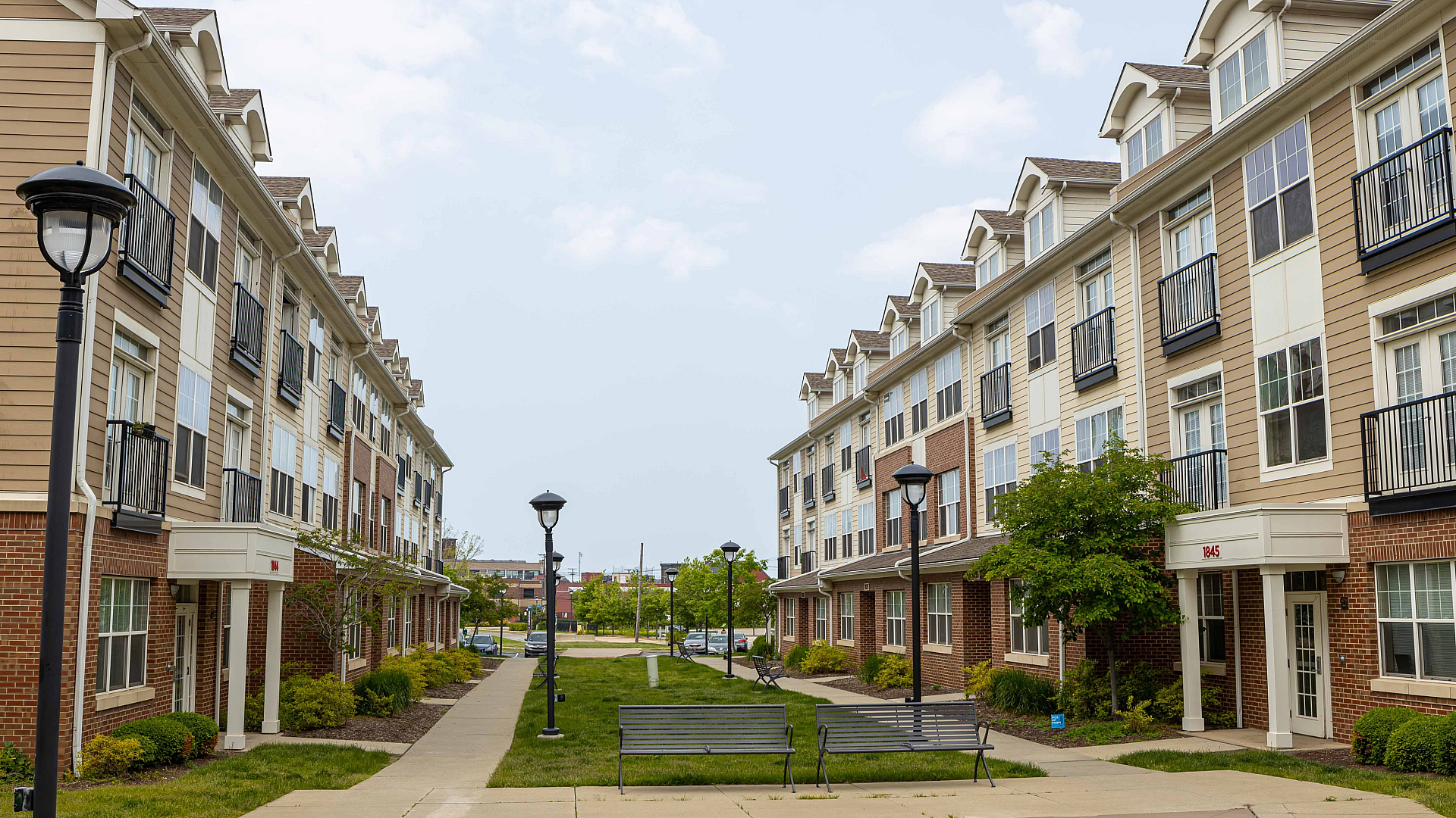 Charming apartment complex with modern architecture, featuring well-maintained pathways and inviting green spaces.