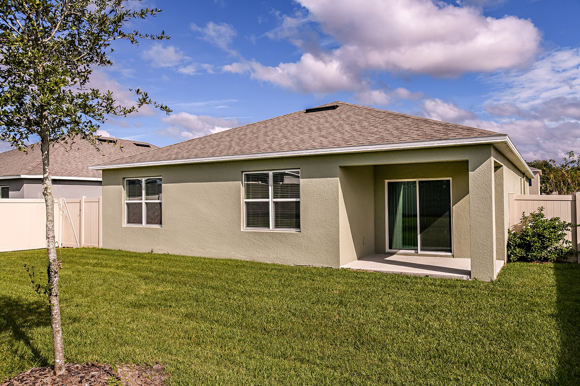 Exterior view of a home for rent with a patio. Beautifully landscaped, fenced in backyard, at a home for rent in Apopka, Florida.