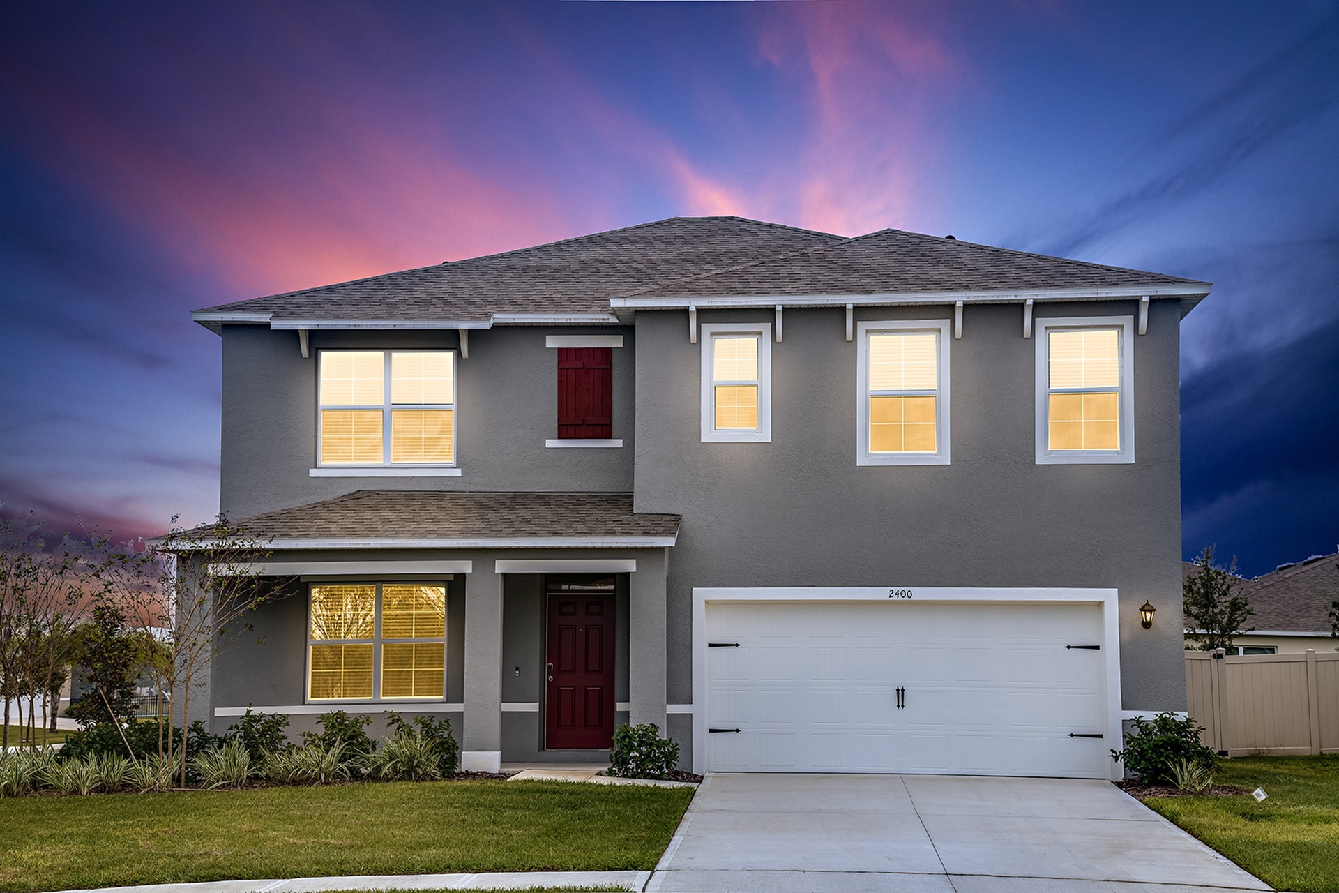 Photograph of the front side exterior of one of our homes in Apopka, FL, featuring a driveway, garage, and green lawn.