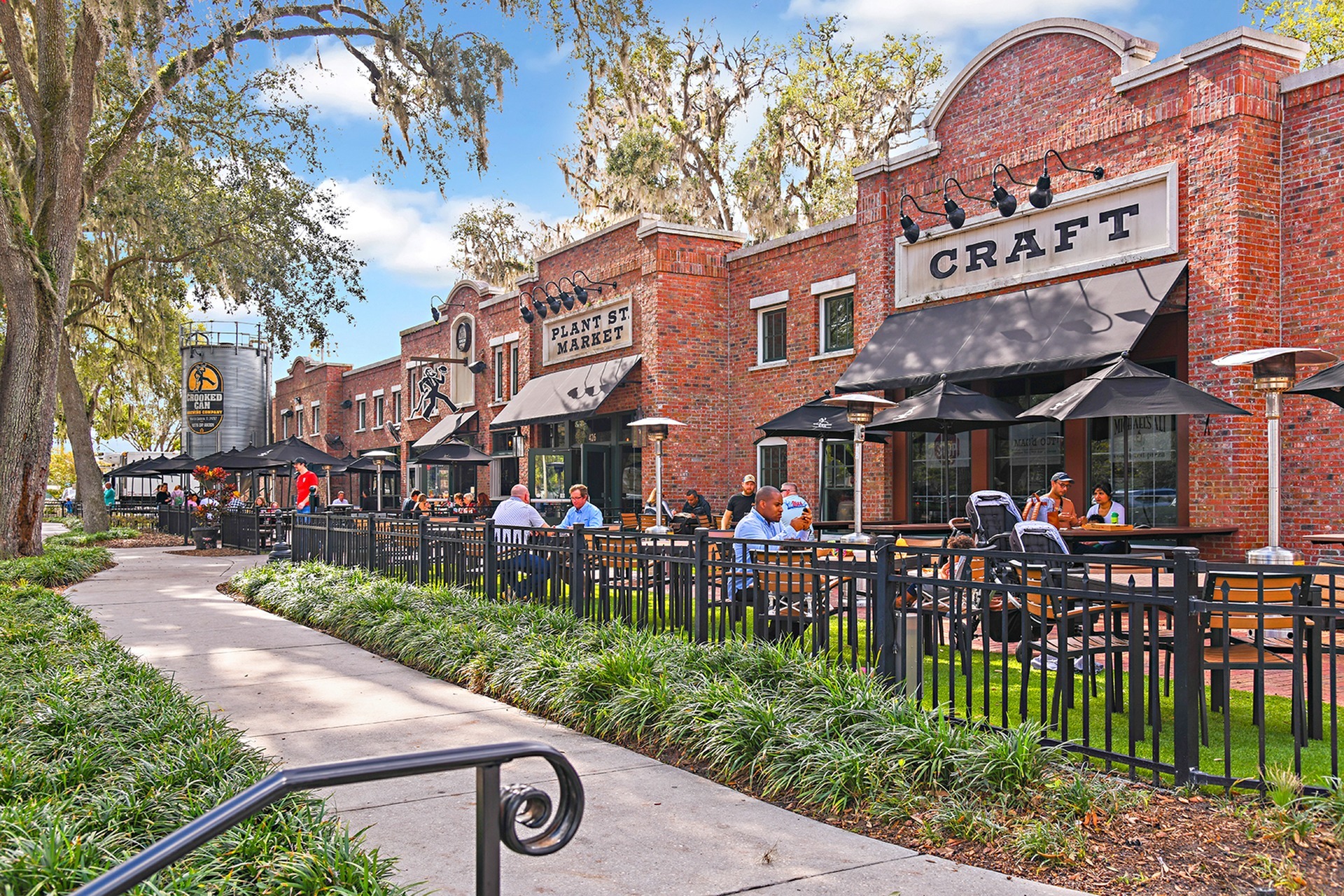 Small business and eateries near our townhomes in Popka, FL, featuring brick facades and people sitting outside dining.