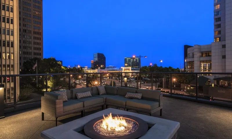Rooftop lounge at our apartments for rent in Atlanta, featuring a fire pit, outdoor couches, and a view of the city.