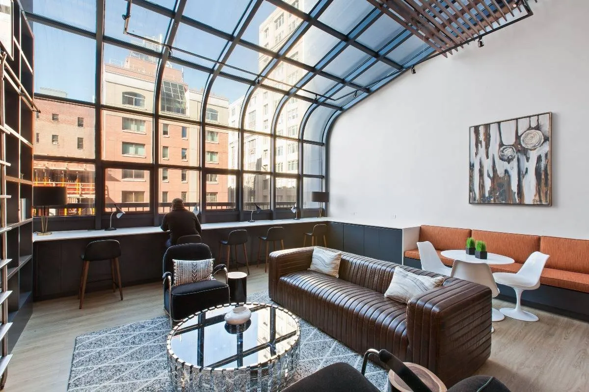 The lounge at our apartments in Chelsea, featuring wood grain floor paneling and glass ceiling panes.