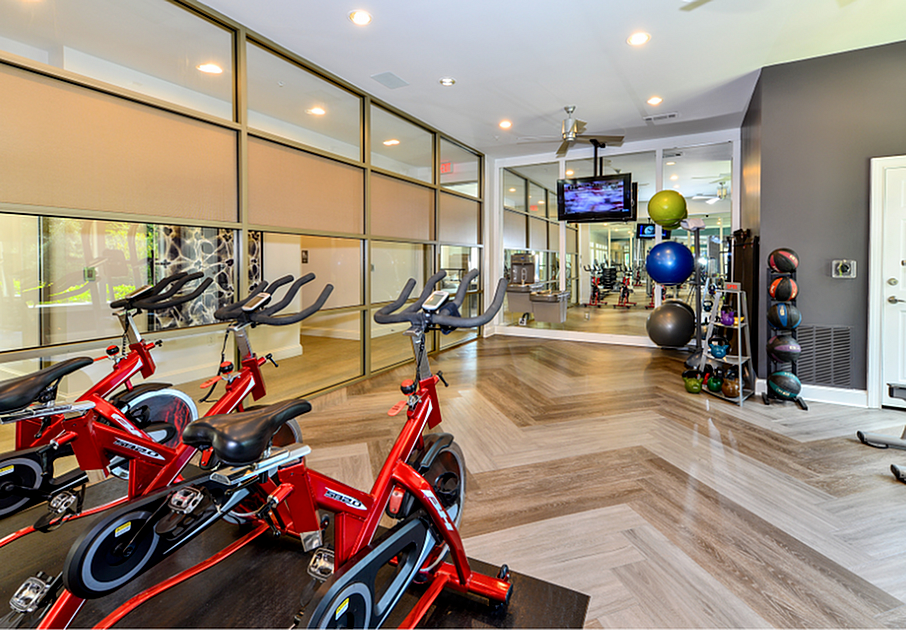 Modern gym with sleek red spin bikes, mirrored walls, and vibrant training equipment.