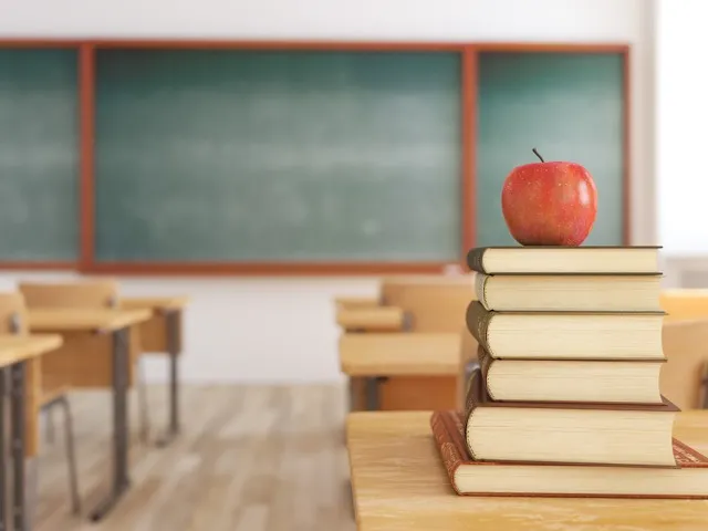 Books on a desk with an apple on top
