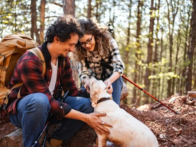 couple outside with dog on trail