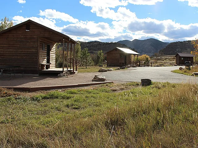 Charming rustic cabins set against a picturesque mountain landscape, ideal for a serene getaway in nature.