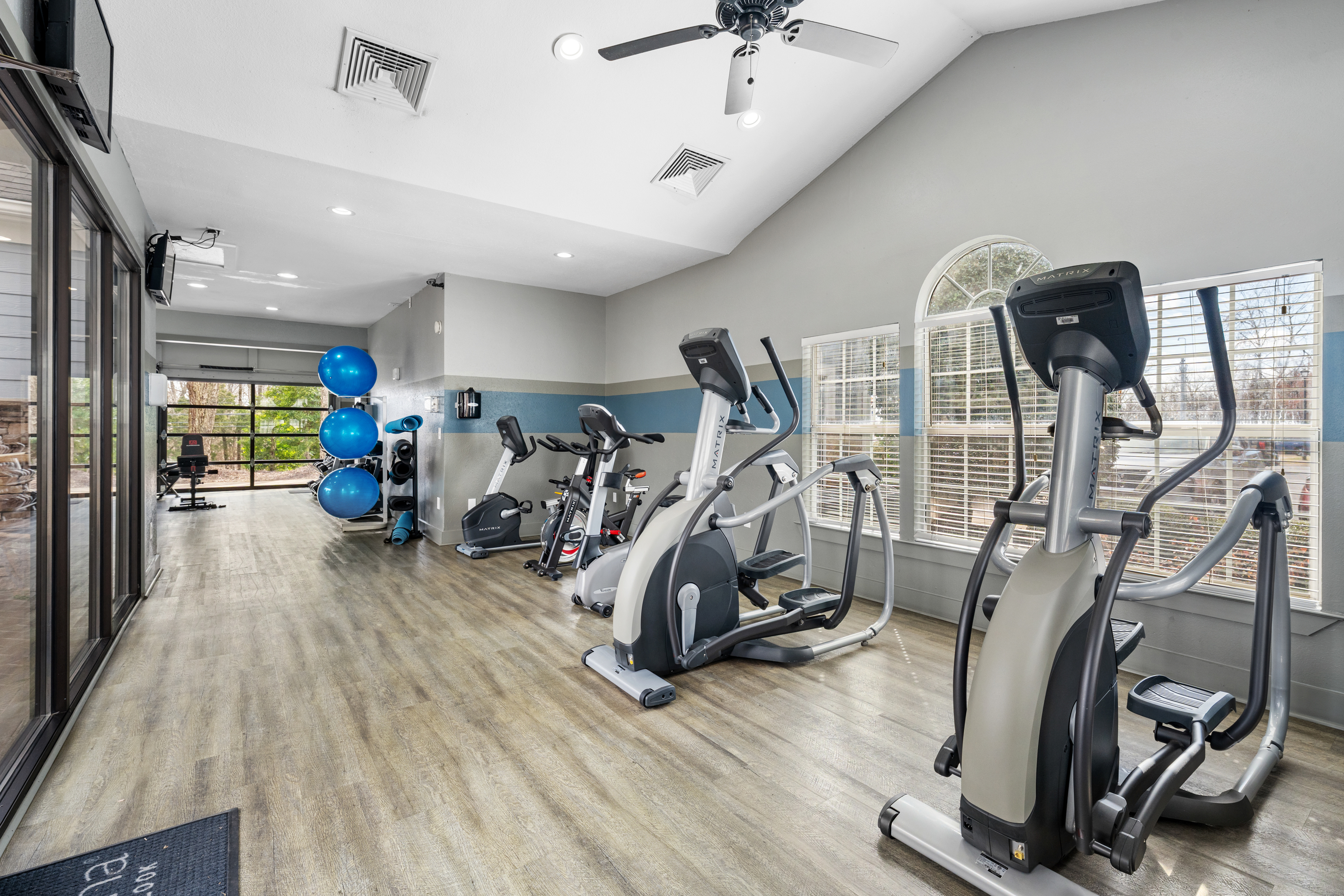 Bright and modern gym facility with state-of-the-art exercise machines, large windows, and sleek design, ideal for fitness enthusiasts.