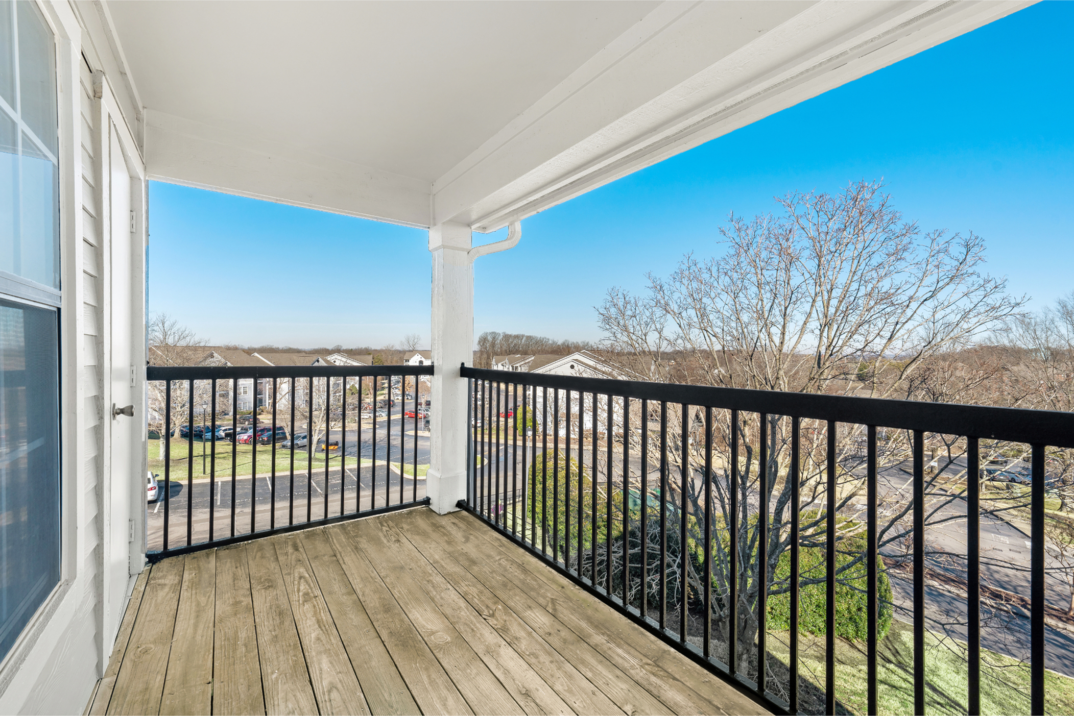 Charming apartment balcony offering a stunning view over a serene landscape, perfect for relaxation.
