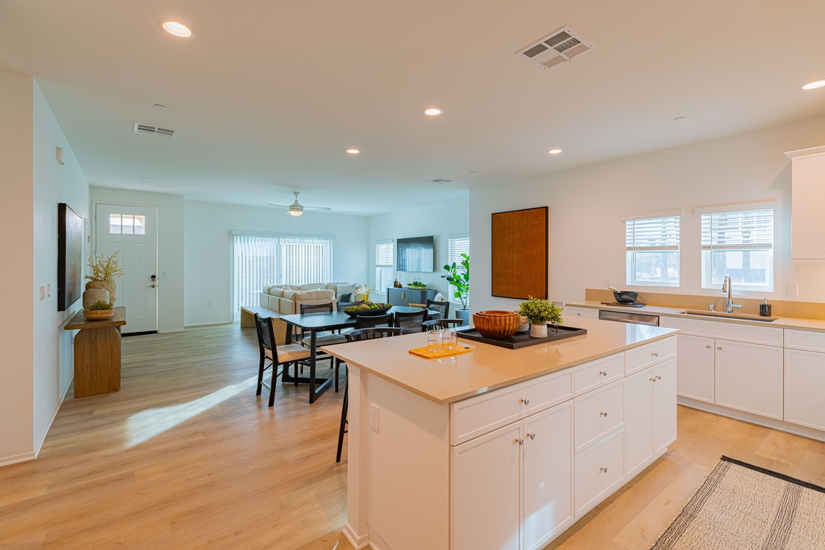 Inviting open-plan floor plan featuring a sleek kitchen with island bar, cozy dining area, and a bright living room with ample natural light.