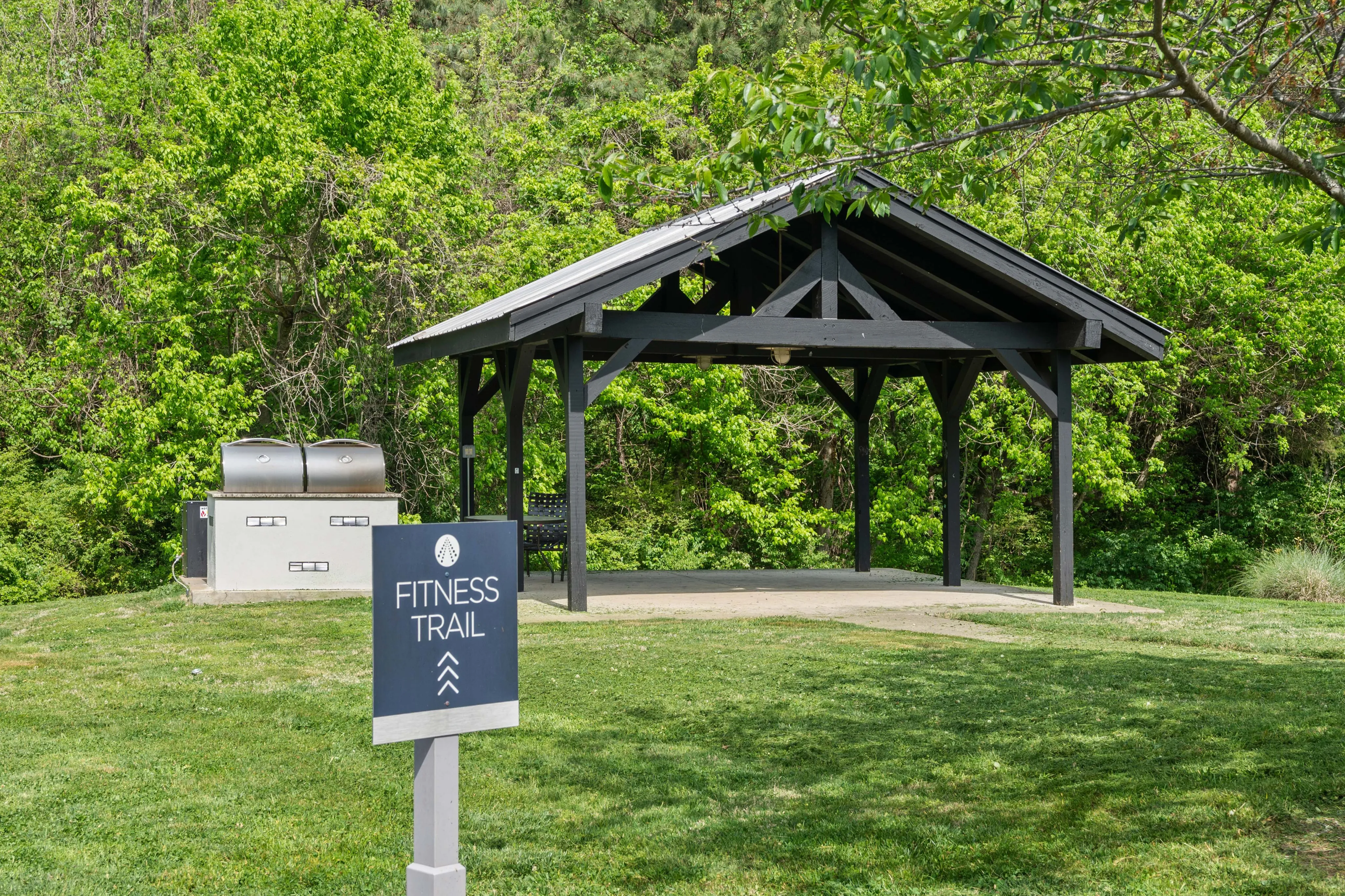 Inviting fitness trail entrance with a charming wooden pavilion and lush green surroundings.