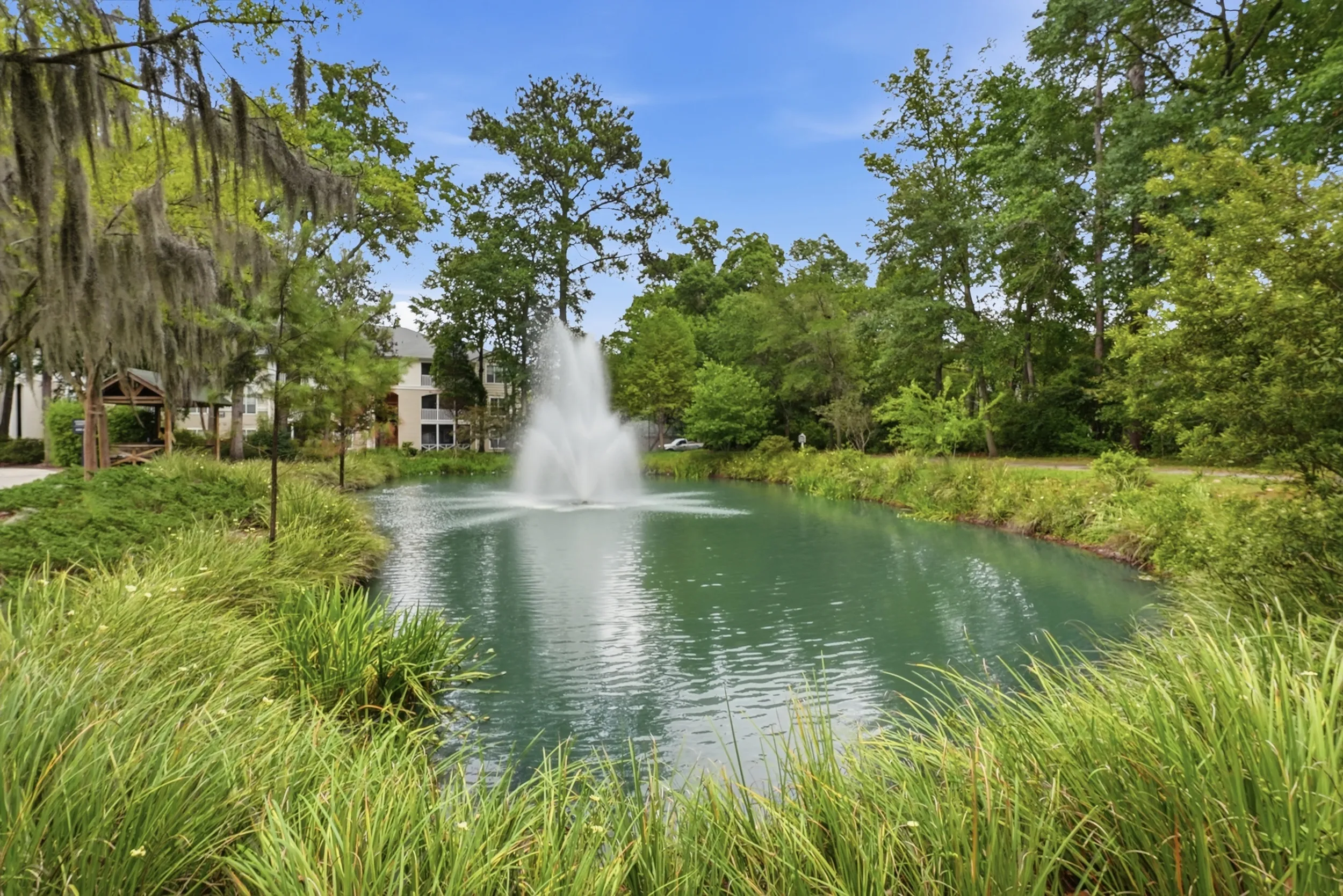 Charming garden-view apartment with a scenic pond, stunning water fountain, and lush greenery.