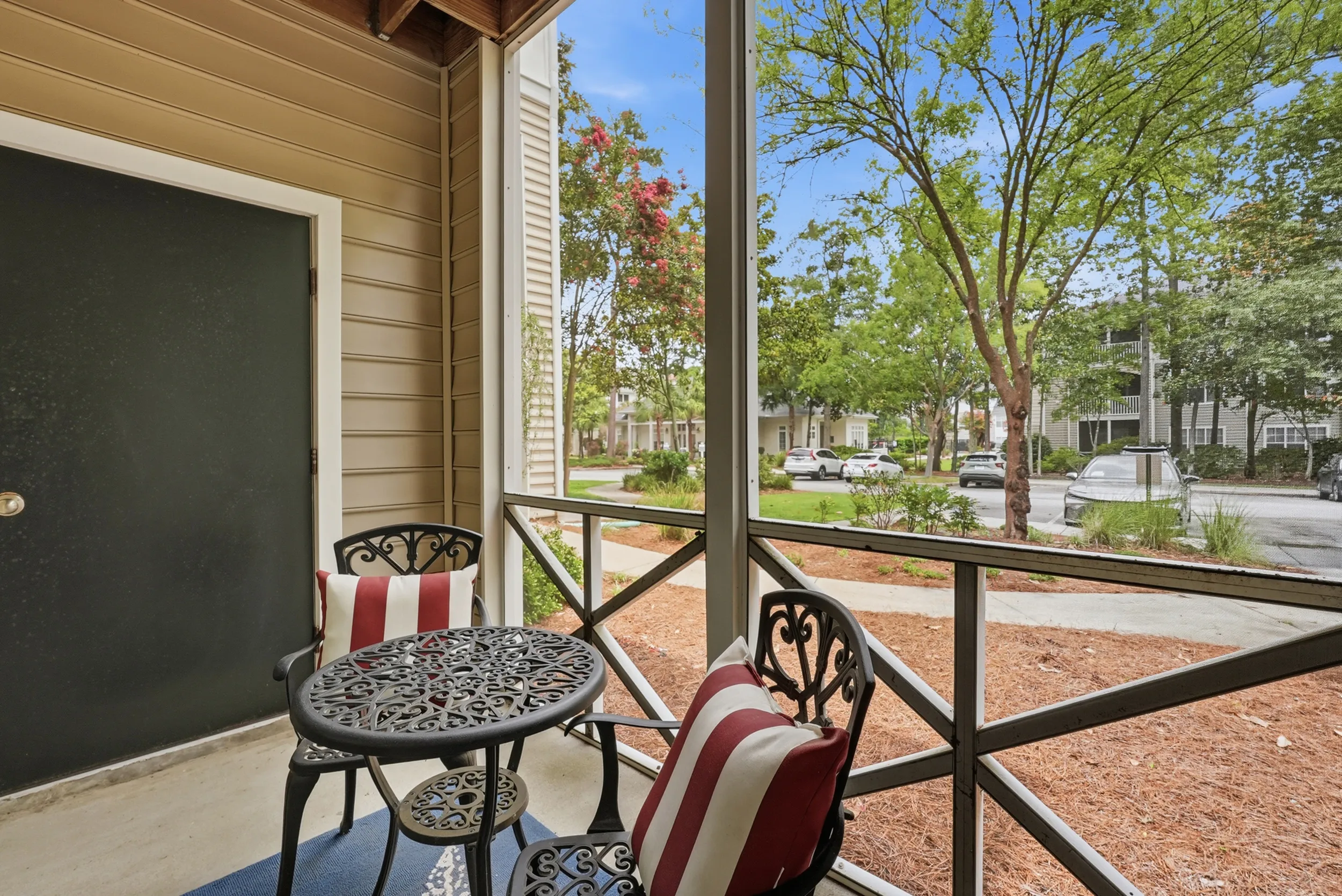 Charming apartment balcony with elegant wrought iron furniture and picturesque garden view.