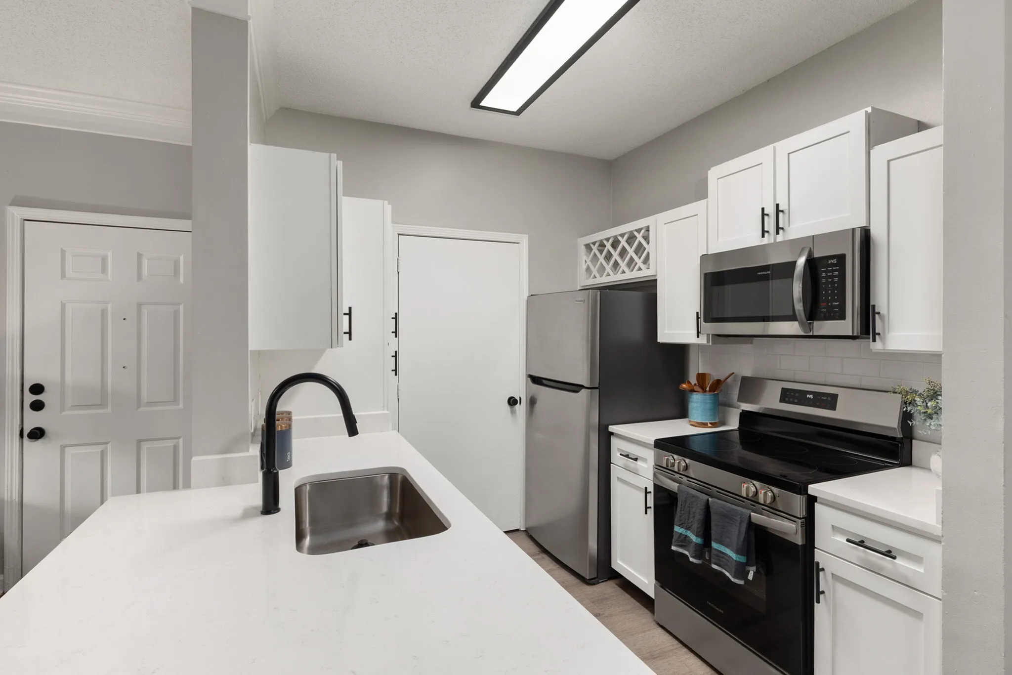 Sleek modern kitchen with stainless steel appliances, elegant white cabinetry, and a stylish black faucet.